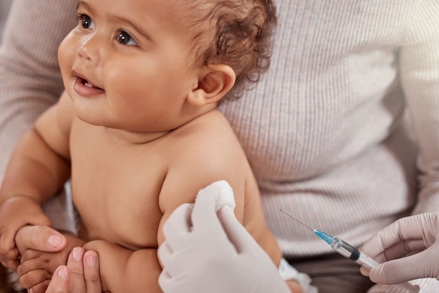 un soignant vaccine un bébé