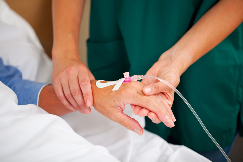 illustration d'un infirmier installant un cathéter à la main d'un patient suivant une chimiothérapie