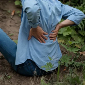 femme ayant chuté par terre et se tenant le dos