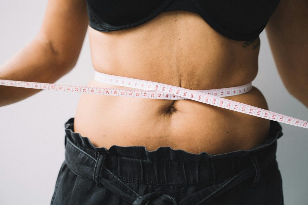 Accueil illustration d'une femme se mesurant son tour de taille avec un mètre, dans une logique de perte de poids