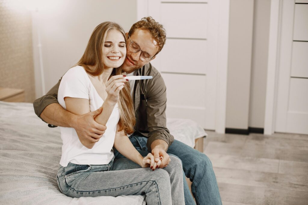 Un couple heureux se réjouissant d'un test de grossesse positif