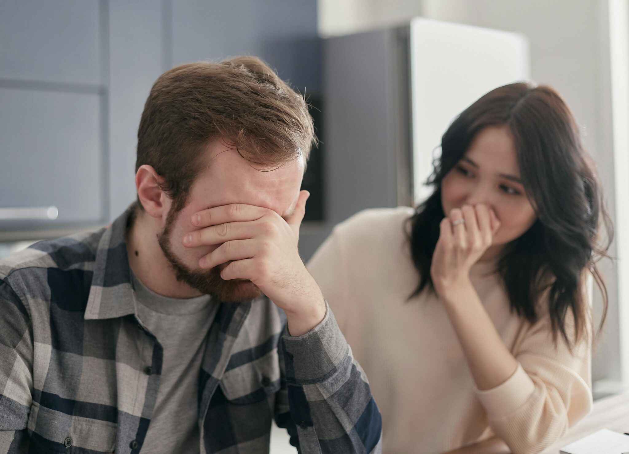 Une femme soutient par sa présence son conjoint, bouleversé par le chagrin et l'inquiétude