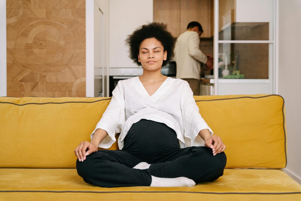 Accueil illustration d'une femme enceinte, assise, les jambes en tailleur et les yeux fermés, en pleine séance de relaxation, pour apaiser ses angoisses
