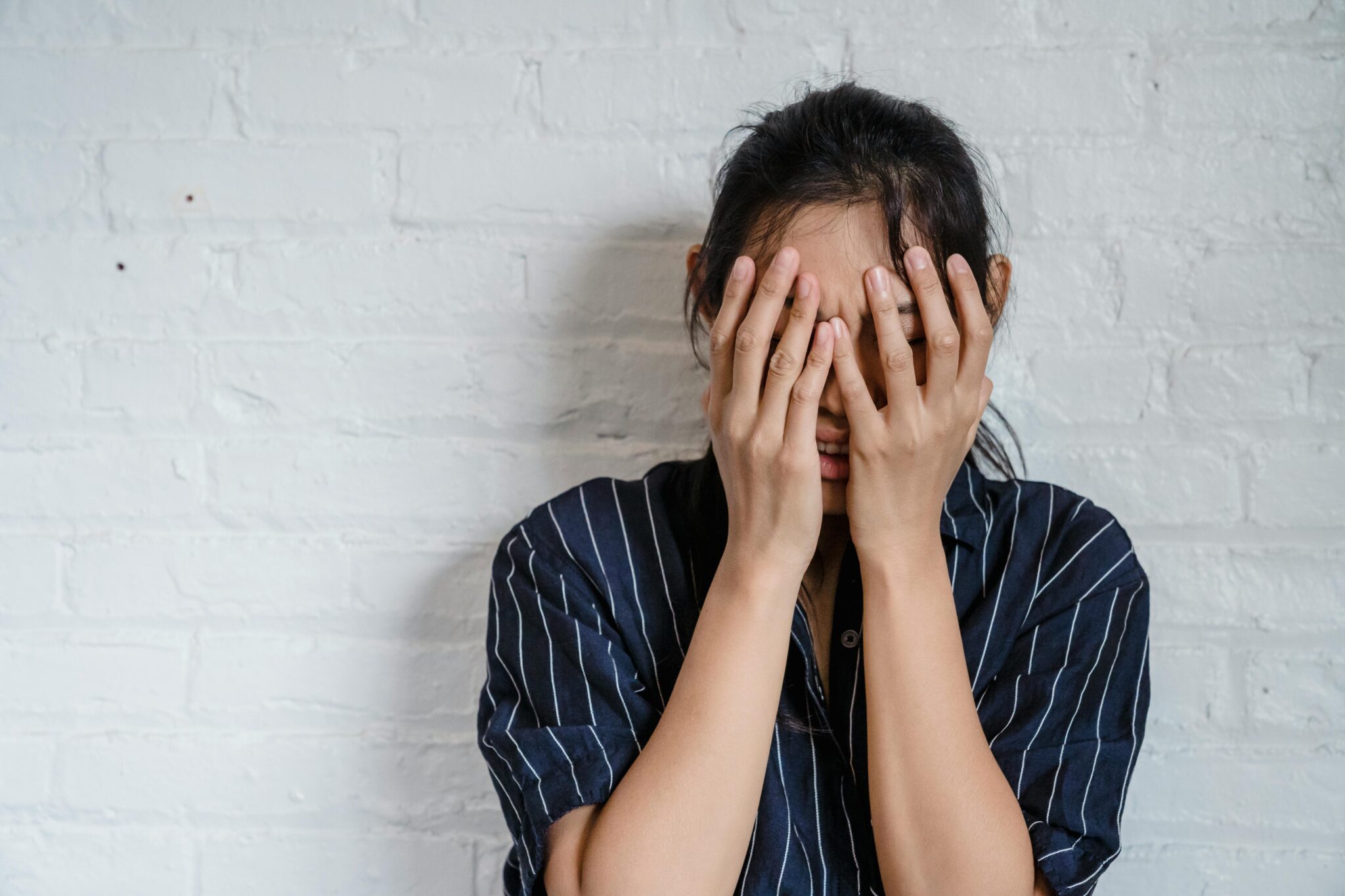 Une jeune femme se couvrant le visage avec les mains, visiblement effrayée