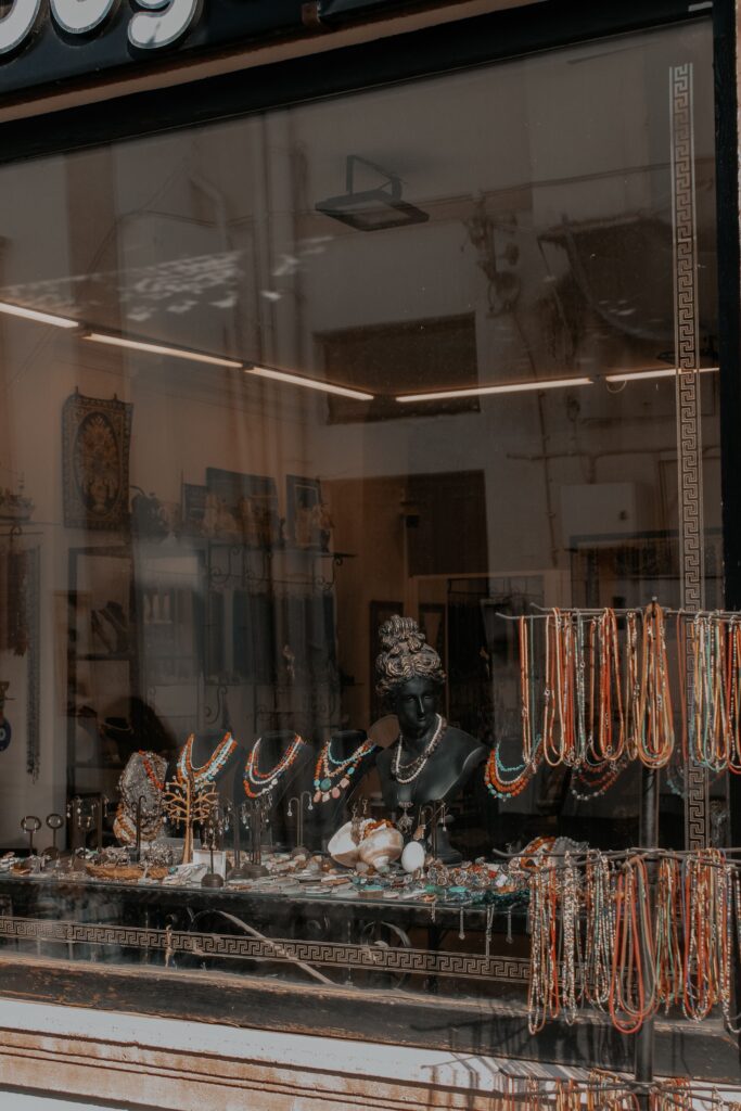 Charming display of colorful necklaces and jewelry in a shop window. Perfect for fashion or retail themes.